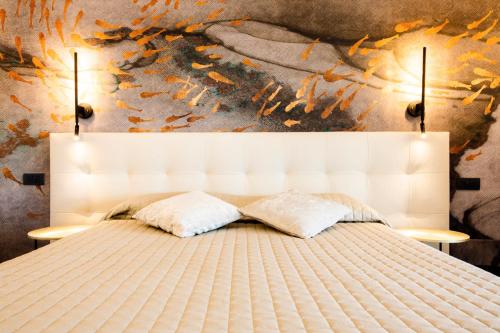 a white bed with two pillows in a bedroom at Bellevue - Rooms & Suites in Levanto
