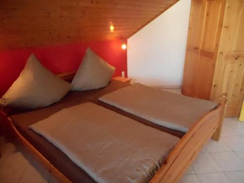 two beds in a room with a red wall at Gästehaus Kathi in Gyenesdiás