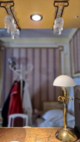 a lamp sitting on a table in a room at Oázis Hotel Étterem in Kiskunfélegyháza