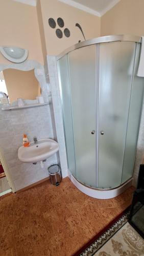 a bathroom with a glass shower and a sink at Oázis Hotel Étterem in Kiskunfélegyháza