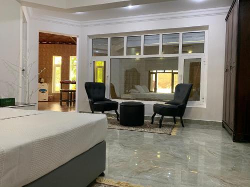 a bedroom with a bed and two chairs and a couch at Oriental Nights Rest House in Al Wāşil
