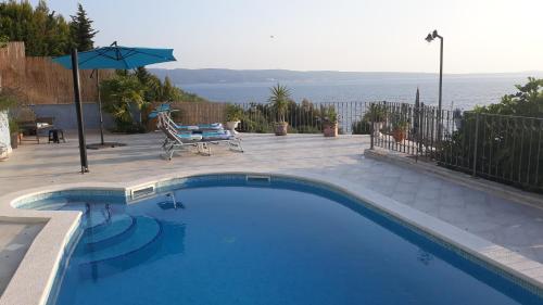 a swimming pool with a chair and an umbrella at Villa Blue View in Sumpetar