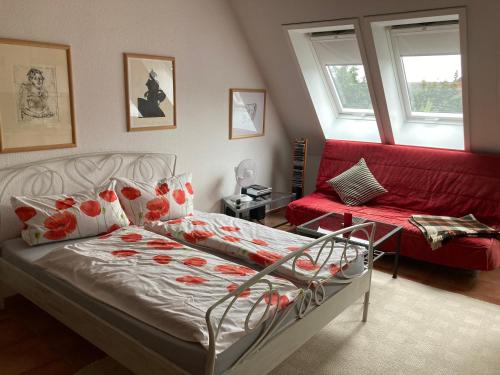 a bedroom with a bed and a red couch at Galerie ebe in Parchim