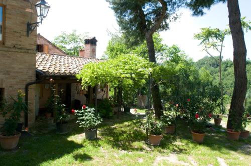 a garden in front of a house with trees and flowers at B&B La Cappellania in Montegiorgio