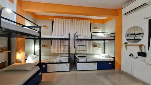 a room with three bunk beds in it at HOSHTEL99 - Stay, Cowork and Cafe - A Backpackers Hostel in Pune