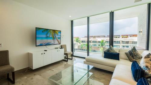 sala de estar con sofá y TV en Oceana 422 Playa del Carmen Condo, en Playa del Carmen