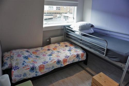 a small bedroom with a bunk bed and a window at Stadswoning voor jonge gezinnen en senioren in Enkhuizen