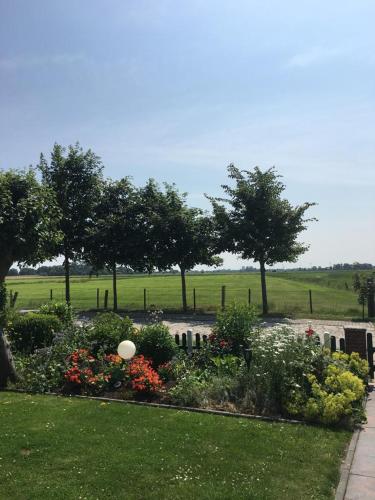 a garden with flowers and trees in a field at Ferienwohnung auf dem Land in Wangerland