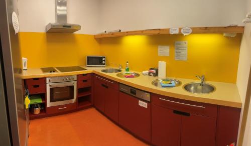 a kitchen with two sinks and a yellow wall at Haus 54 in Zingst