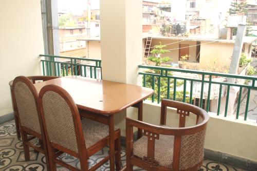 a dining room table with chairs and a window at Trekkers Home in Kathmandu