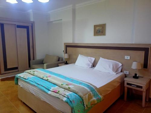 a bedroom with a large bed and a chair at Oasis marsa alam in Marsa Alam City