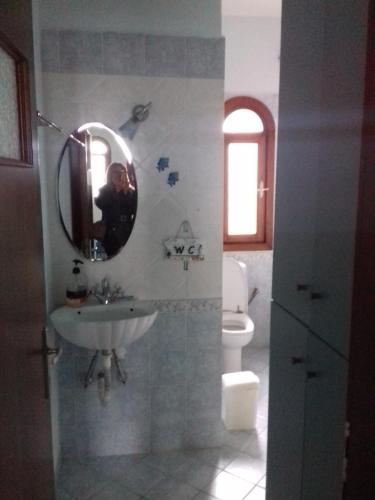 a bathroom with a sink and a mirror and a toilet at Marianthi's House in Metamorfosi