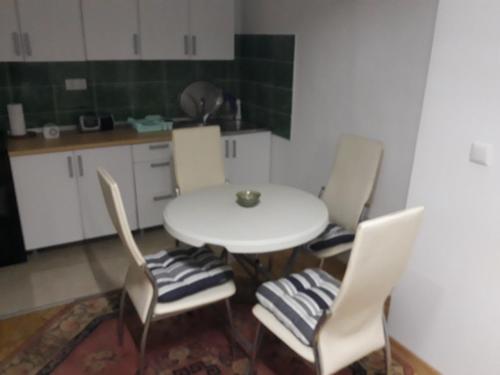 cocina con mesa blanca y 4 sillas en Apartman Sara, en Sarajevo