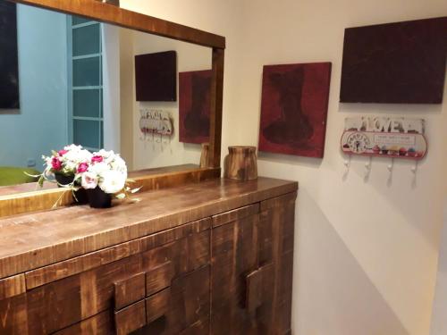 un baño con espejo y un jarrón de flores en un mostrador en Lovely apartment premium location, en Ramat Gan