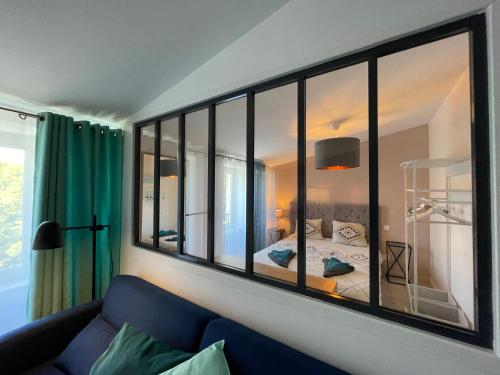 1 dormitorio con espejo grande en la pared en Chez Emile La Chabotine -T2 Neuf, calme, lumineux, en Niort