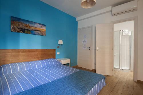 Dormitorio azul con cama y pared azul en Sciuscettùa Rooms, en La Spezia