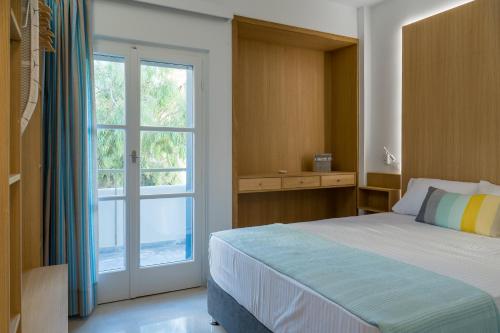 a bedroom with a bed and a large window at CHROMA Lodge Rafina in Rafina