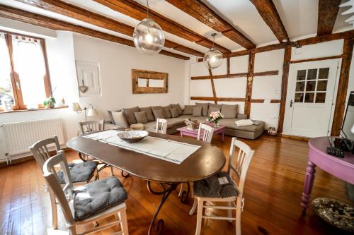 un salon avec une table et des chaises dans l'établissement Les Appartements De Louise, à Riquewihr