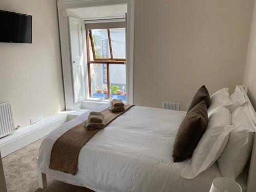a bedroom with a bed with two pillows and a window at The Old Exchange in Clifden