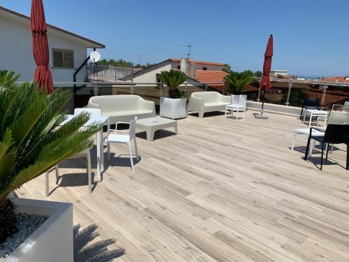 a patio with white tables and chairs on a roof at Tenuta Micoli in Frisa