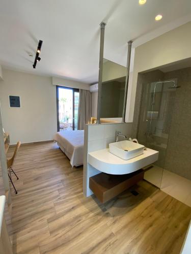 a bathroom with a sink and a bed and a mirror at Roula Kotsonis Superior Apartment in Argasi