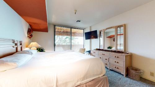 a bedroom with a large white bed and a dresser at Bridges #105 Condo in Mammoth Lakes