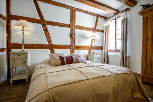 a bedroom with a large bed in a room with wooden ceilings at Les Appartements De Louise in Riquewihr