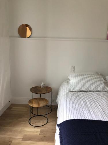1 dormitorio con cama y taburete junto a una mesa en Chambre indépendante au Manoir de la Célinais côté jardin en Saint-Aubin-du-Cormier
