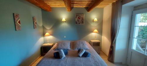 ein Schlafzimmer mit einem Bett mit zwei Nachttischen und zwei Lampen in der Unterkunft Chambre Malon Mas Bel Esperance in Saint-André-dʼOlérargues