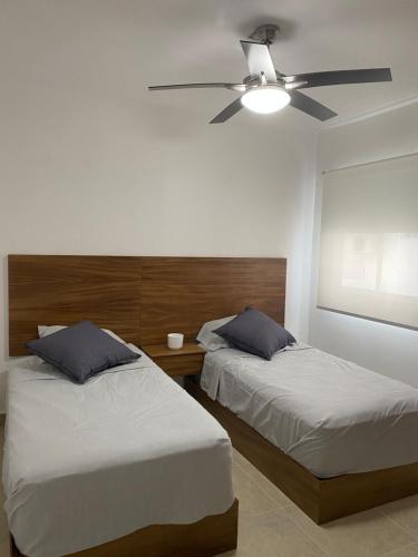a bedroom with two beds and a ceiling fan at Liverte Cancún downtown in Cancún