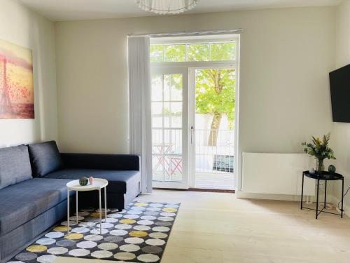 a living room with a blue couch and a table at aday - 2 bedroom apartment with Patio in Aalborg