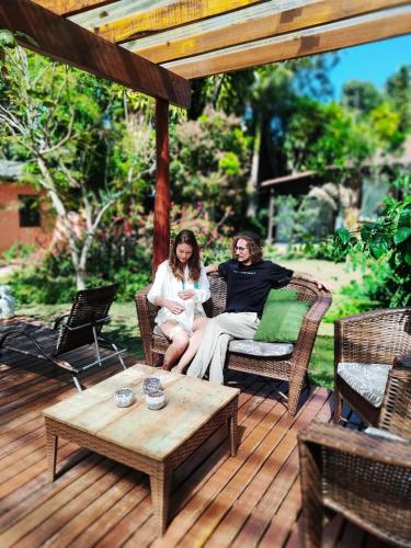 two women sitting on a patio table on a deck at Pousada Alfa e Ômega in Alto Paraíso de Goiás