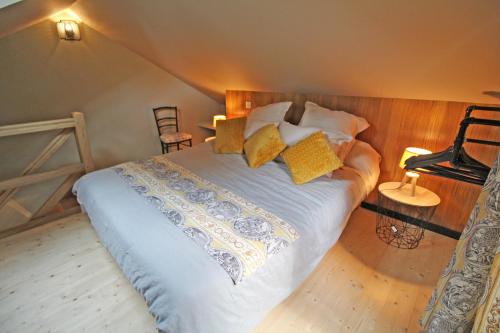 a bedroom with a large bed with yellow pillows at LA PETITE CHARMILLE in Châteauponsac