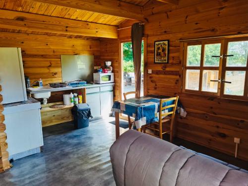 a kitchen with a couch and a table in a cabin at Studio Domaine du vieux chêne in Bergerac