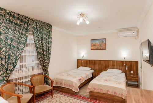 a hotel room with two beds and a chair at Hotel Dilshoda in Samarkand