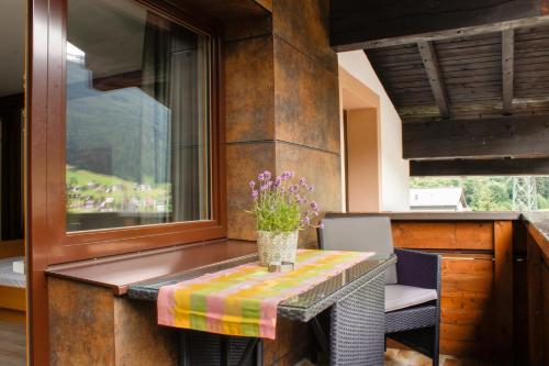 una mesa con un jarrón de flores en ella en una cocina en Haus Ganeu, en Gaschurn