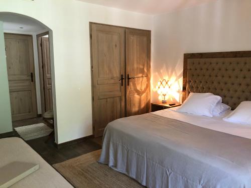a bedroom with a large bed with a wooden headboard at Le Clos des Sept Palmiers in Cavalaire-sur-Mer