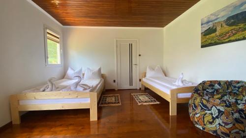 a room with two beds and a chair in it at Casa Kelemen Irén in Rimetea