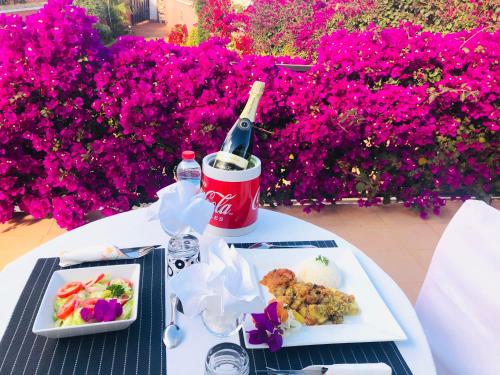een tafel met twee borden eten en een fles wijn bij Petite Flower Guest House in Talata-maty