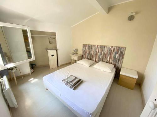 ein Schlafzimmer mit einem weißen Bett und einem Handtuch darauf in der Unterkunft LaPoterie in Vallauris