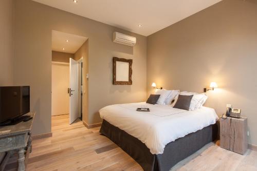 a bedroom with a large bed and a flat screen tv at B&B Louis1924 in Dilbeek