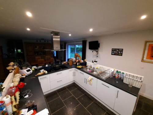 une cuisine avec des armoires blanches et un comptoir noir dans l'établissement La Flandre entre plaine, mer et marais, à Rubrouck