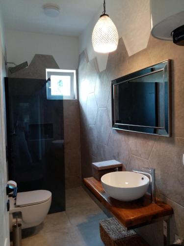 a bathroom with a sink and a tv on the wall at Luxury apartment Tamaris by the sea in Nin