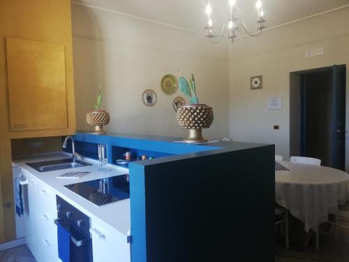 a kitchen with a blue counter and a table at Casale Di Benedetto in Caltagirone
