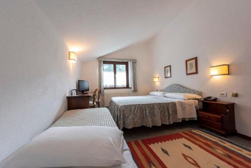 - une chambre avec 2 lits et une fenêtre dans l'établissement Hotel Triolet, à Courmayeur