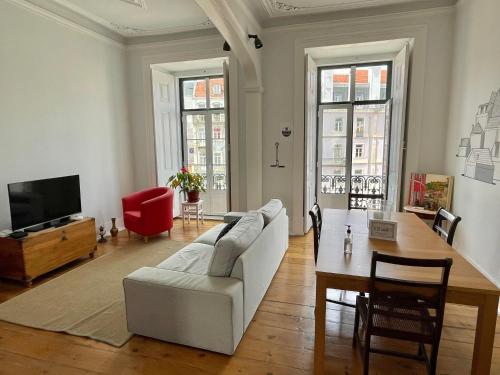 ein Wohnzimmer mit einem weißen Sofa und einem Tisch in der Unterkunft Lisbon Check-In Guesthouse in Lissabon