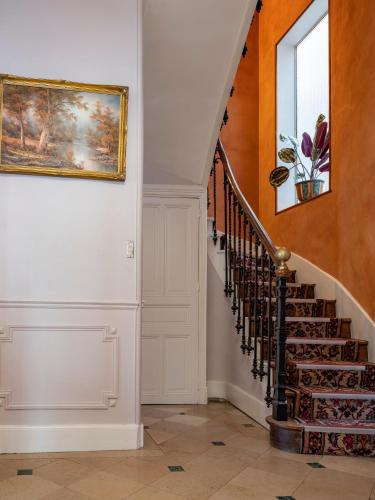 a staircase in a home with a painting on the wall at La Villa François Premier in La Bourboule
