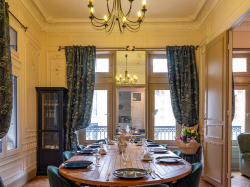 a dining room with a long table and a chandelier at La Villa François Premier in La Bourboule