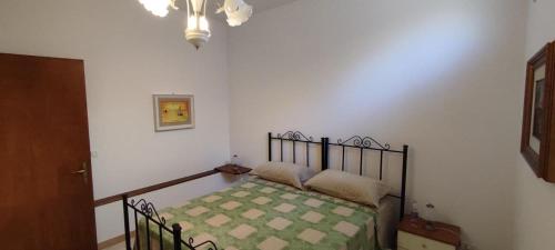 een slaapkamer met een bed met een groen en wit patroon bij Casa vacanza Marina di Andrano zona Grotta Verde in Andrano