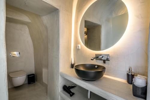 a bathroom with a bowl sink and a mirror at Anila Suites in Fira
